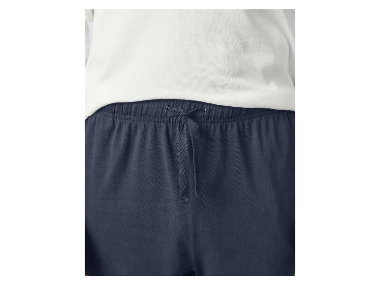 Close-up van een wit t-shirt en marineblauwe joggingbroek met trekkoord.