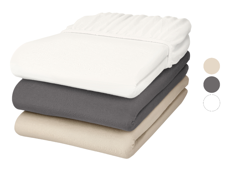 Stapel van drie hoeslakens in wit, grijs en beige, met kleurstalen.