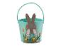 Een felgroene paasemmer met konijn en bloemen.