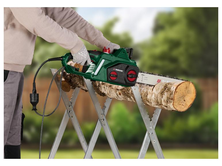Een man gebruikt een Parkside elektrische kettingzaag om hout te zagen op een bok.