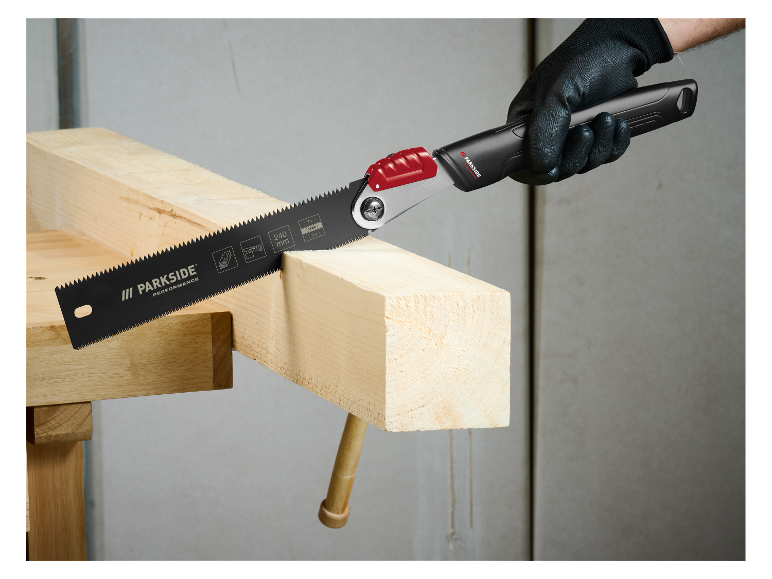 Een man gebruikt een Parkside zaag om hout te zagen.