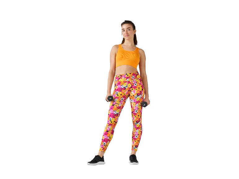 Vrouw in bloemetjes leggings en oranje topje, oefent met dumbbells.