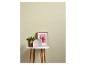 Groene plant, roze en grijze huisdecoraties en een ingelijste bloemenfoto op een witte tafel.