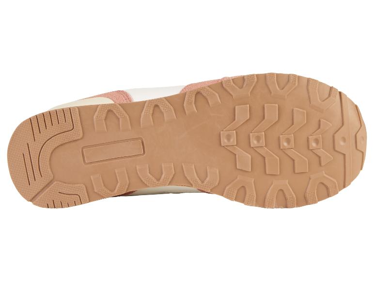 De onderkant van een roze en witte sneaker met een bruine zool.