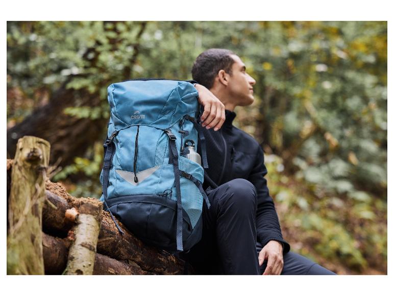 Een man met een blauwe Crivit-rugzak in een bos