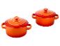 Twee feloranje keramische ovenschalen met deksels en handvatten.