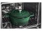 Groene gietijzeren braadpan in een oven op een rooster