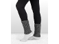 Vrouw draagt zwarte leggings, witte sokken en grijze gebreide beenwarmers.