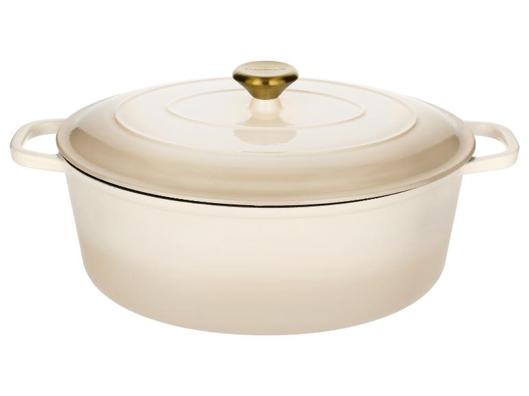 Crèmekleurige geëmailleerde gietijzeren braadpan met gouden knop op het deksel.