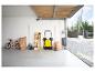 Garage met gele veegmachine, fiets, tuingereedschap en opklapbare tafels.