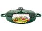 Groene gietijzeren braadpan met deksel, gevuld met courgettespaghetti en tomaten.