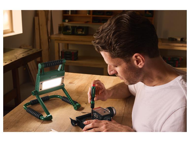 Man aan het werk in een werkplaats verlicht door de PARKSIDE LED-bouwlamp.