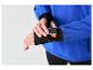 Man in blauwe jas en zwarte legging, stelt smartwatch met oranje band in.