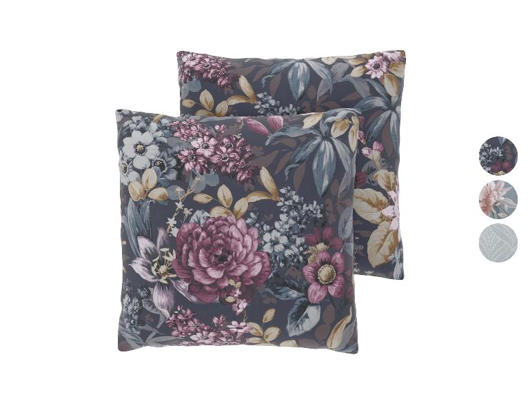 Twee kussens met bloemenpatroon, donkere achtergrond en kleurrijke bloemen