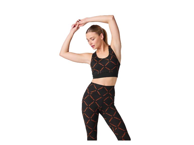 Vrouw in sportkleding, zwarte sportbeha en legging met patroon.