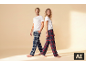 Man en vrouw in witte T-shirts en geruite pyjamabroeken, glimlachend.