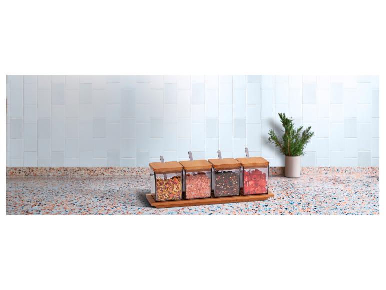 Kruiden, roze zout en gedroogd fruit in glazen potten op een houten rek.