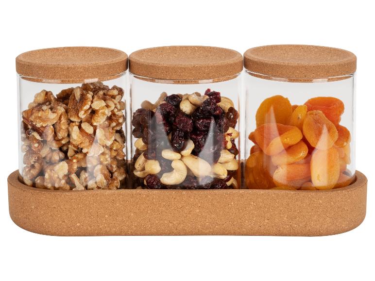 Walnoten, mix van gedroogd fruit en gedroogde abrikozen in glazen potten met kurken deksels.