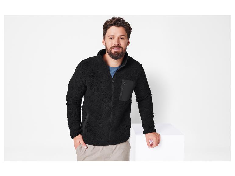 Man draagt een zwarte fleecejas met rits.