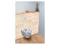 Toilet met blauw-wit patroon zitting in een badkamer met lichte houten lambrisering.