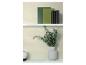 Boeken en een vaas met eucalyptus takken op witte planken tegen een getextureerde muur.