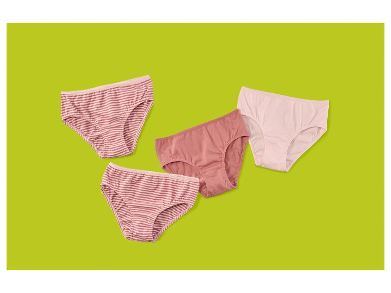 Vier paar damesonderbroeken in roze en gestreepte patronen op een groene achtergrond