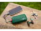 Groene powerbank laadt smartphone op, met sleutels en mini-boormachine sleutelhanger.