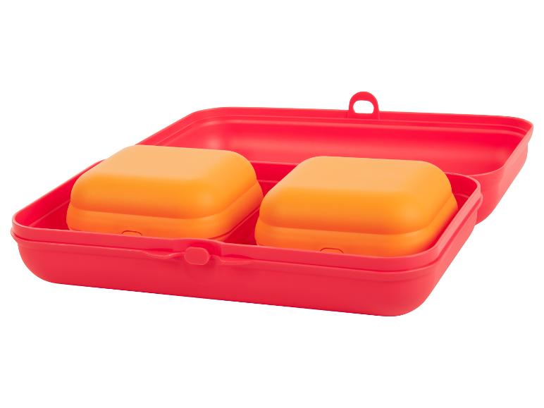 Rode lunchbox met twee oranje bakjes.