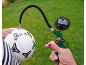 Digitale bandenspanningsmeter die een voetbal oppompt op een grasachtergrond.
