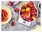 Keukenweegschaal met appels, taartbodem met jam en bakingrediënten.