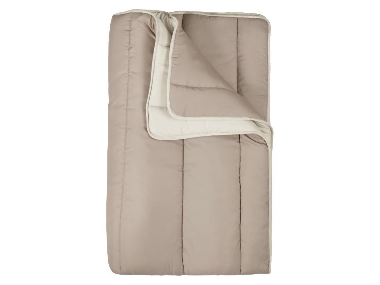 Beige dekbed of slaapzak met crèmekleurige binnenvoering, opgevouwen