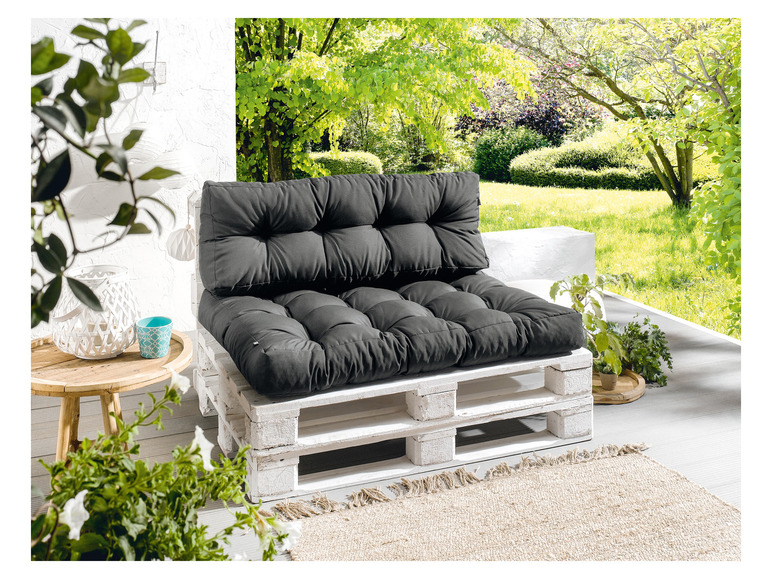 Een grijze palletkussenset voor buiten op een wit geverfd pallet.