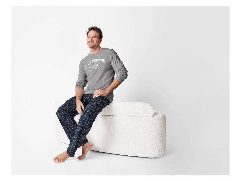 Man ontspant in geruite pyjama met een shirt met lange mouwen.