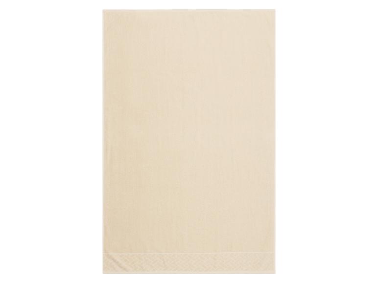 Beige badhanddoek met decoratief patroon aan de rand