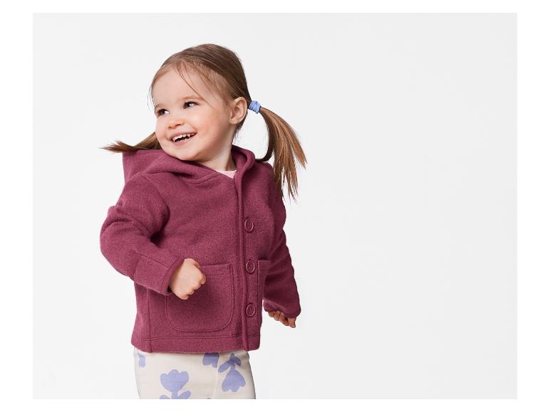 Lachend kind in roze jas met capuchon.