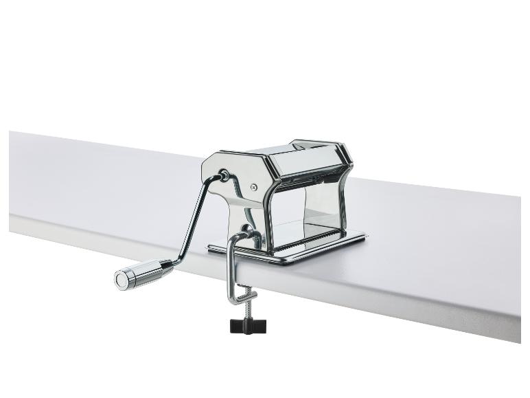 Verchroomde pastamachine, vastgeklemd aan een tafel.