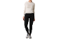 Vrouw in wit shirt met lange mouwen en zwarte sportlegging met sportschoenen.