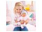 Lachend meisje houdt babypop vast in roze kleding en grijze muts.