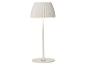 Witte tafellamp met geplooide lampenkap en ronde voet.