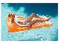 Vrouw in bikini drijft op een oranje opblaasbaar luchtbed in een zwembad.