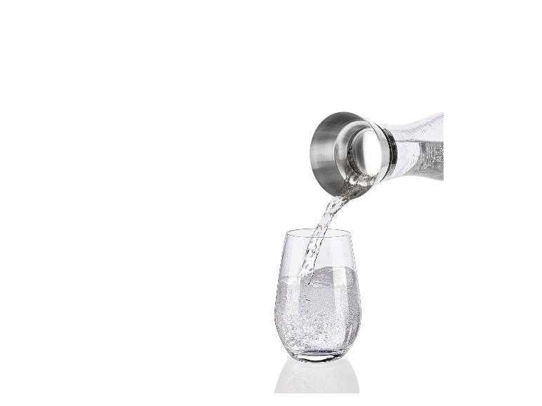 Water wordt uit een kan in een glas gegoten.