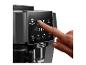 Vinger drukt op de Espresso-knop op het bedieningspaneel van een De'Longhi koffiezetapparaat.
