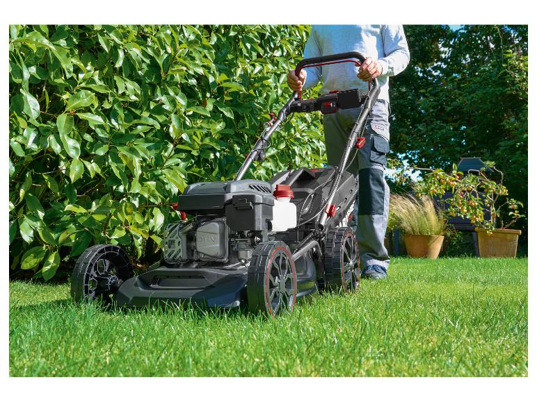 Man maait gras met een Parkside grasmaaier in een tuin.