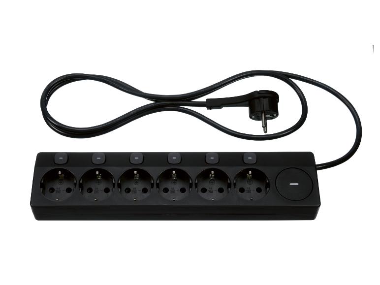 Een zwart stekkerblok met zes stopcontacten en een opgerolde kabel, op een witte achtergrond.