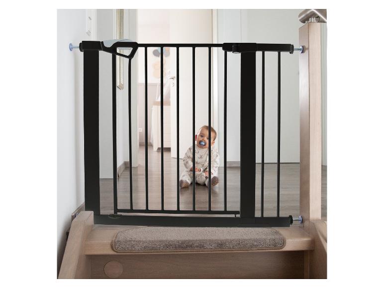 Babyveiligheidshekje op een trap met een baby die erachter zit.