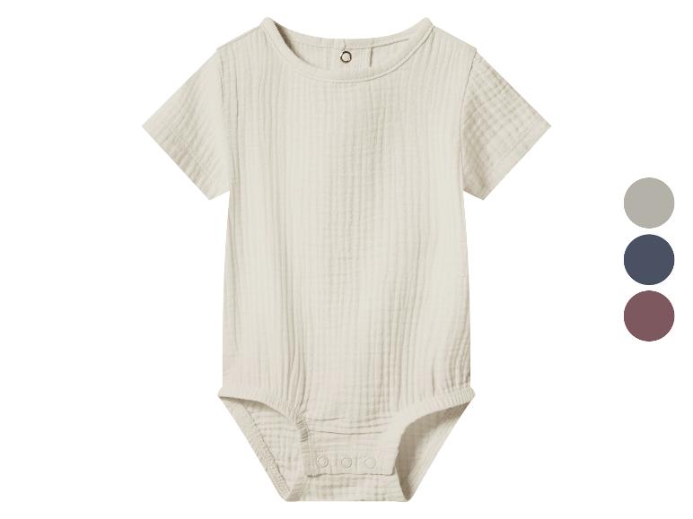 Beige baby romper met korte mouwen en knoopjes, met kleurenpalet ernaast.