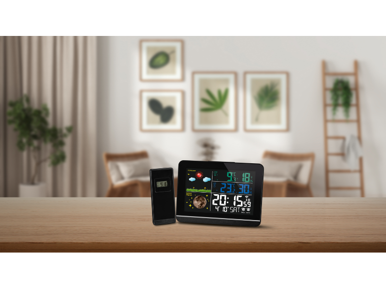 Weerstation en sensor op houten tafel met moderne woonkamer op de achtergrond.