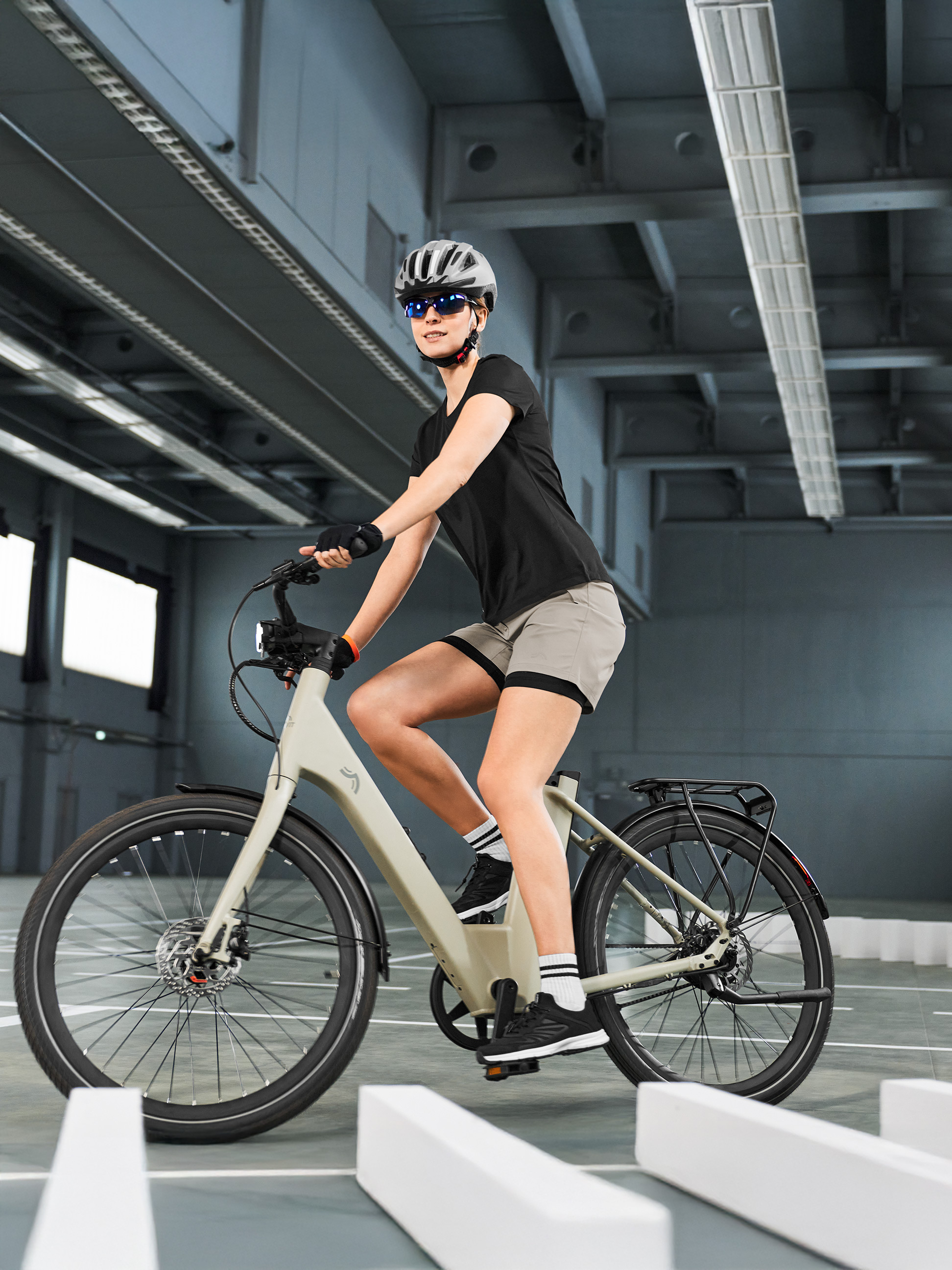 Vrouw in fietskleding op een e-bike, navigerend op een indoor parcours.