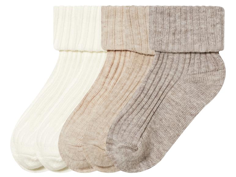 Drie paar gebreide sokken in beige, wit en grijs