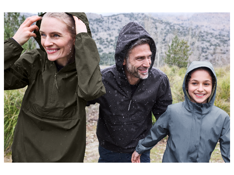 Een gezin geniet van een sneeuwrijke wandeling in hun regenjassen.